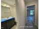 Hallway leading to a full bathroom with a grey vanity at 205 Regis Ln # 11, Coats, NC 27521