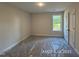 An empty bedroom with a window showing mature trees at 205 Regis Ln # 11, Coats, NC 27521