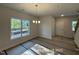 Sunlit dining area featuring a modern chandelier, a large window with natural views, and unfinished flooring at 205 Regis Ln # 11, Coats, NC 27521