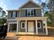 Charming two-story home with gray siding, black shutters, and a welcoming front porch with white columns at 205 Regis Ln # 11, Coats, NC 27521