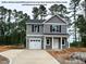 Charming two-story home with gray siding, white trim, attached garage, and inviting front porch at 205 Regis Ln # 11, Coats, NC 27521