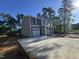 View of the new home featuring a long driveway, two-story construction, and a well-lit exterior, surrounded by trees at 205 Regis Ln # 11, Coats, NC 27521