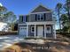 This home offers a classic design with gray siding, a one-car garage, and a covered entrance, set against a blue sky at 205 Regis Ln # 11, Coats, NC 27521