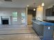 Open kitchen view including fireplace, gray cabinets, stainless steel sink in the island, and lots of light at 205 Regis Ln # 11, Coats, NC 27521