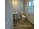 This powder room features a pedestal sink, a modern toilet, and a window with natural light; the flooring is unfinished at 205 Regis Ln # 11, Coats, NC 27521