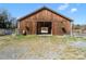 Wood barn with large sliding doors, green space, and a bright blue sky at 2142 Henderson Tanyard Rd, Pittsboro, NC 27312