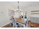 Cozy dining area featuring a rustic chandelier, hardwood floors, and a painting of a horse on the wall at 2142 Henderson Tanyard Rd, Pittsboro, NC 27312
