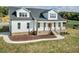 Beautiful new two-story farmhouse with white siding, black roof, welcoming porch, and well-manicured front yard at 2142 Henderson Tanyard Rd, Pittsboro, NC 27312