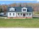Charming home with a covered front porch, white siding, and a well-manicured lawn at 2142 Henderson Tanyard Rd, Pittsboro, NC 27312