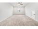 Spacious, carpeted room with a ceiling fan and window providing natural light, with a small access door at 217 Mallard Loop Dr, Clayton, NC 27527