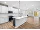 Open-concept kitchen featuring a large center island, stainless appliances, and wood floors at 217 Mallard Loop Dr, Clayton, NC 27527