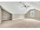 Large attic space with carpeted floors, a fan, and window allowing natural light at 220 Shawnee Dr, Louisburg, NC 27549