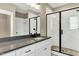 Modern bathroom with glass enclosed shower, white cabinets, and dark countertop at 220 Shawnee Dr, Louisburg, NC 27549
