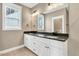 Bright bathroom featuring a double vanity with granite countertop, and a large window at 220 Shawnee Dr, Louisburg, NC 27549