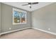 Carpeted bedroom featuring a large window with wooded views and a ceiling fan at 220 Shawnee Dr, Louisburg, NC 27549