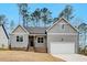 New construction features gray siding, a driveway leading to an attached garage, and low maintenance yard at 220 Shawnee Dr, Louisburg, NC 27549