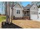 Charming home with light gray siding, brick foundation, dark roof, and well-maintained landscaping at 220 Shawnee Dr, Louisburg, NC 27549