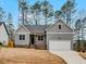 Charming new construction home with gray siding, a front porch, and an attached garage at 220 Shawnee Dr, Louisburg, NC 27549