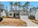Well-manicured lawn, gray siding, brick foundation, and a driveway leading to the attached garage at 220 Shawnee Dr, Louisburg, NC 27549