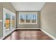 Bright living room with hardwood floors, three windows, and a glass door leading to the backyard at 220 Shawnee Dr, Louisburg, NC 27549