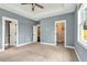 Spacious carpeted main bedroom with tray ceilings, fan, closet, and access to the backyard at 220 Shawnee Dr, Louisburg, NC 27549