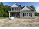 Charming two-story home featuring gray siding, black shutters and a welcoming front porch with stone accents at 226 Rolling Pasture Way, Sanford, NC 27332