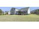 Wide shot of back of house, screened in porch, deck, and large green backyard at 236 Star Valley Dr, Angier, NC 27501