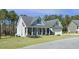 Charming home with a covered front porch, manicured lawn, and an American flag at 236 Star Valley Dr, Angier, NC 27501