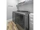 Modern laundry room featuring gray front-load washer and dryer, shelving, and ample space at 236 Star Valley Dr, Angier, NC 27501