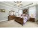 Spacious bedroom with tray ceiling, fan, carpet, and dresser with mirror at 236 Star Valley Dr, Angier, NC 27501