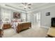 Bedroom featuring a ceiling fan, carpeted floor, and a glimpse of the ensuite bathroom at 236 Star Valley Dr, Angier, NC 27501
