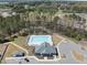Aerial view of community pool, with seating and community center near wooded area at 239 Hopper Cir, Clayton, NC 27520