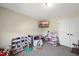Neutral-toned ' room featuring a large TV, toy storage, and play kitchen set at 239 Hopper Cir, Clayton, NC 27520