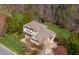 Aerial view of the stately two-story brick home with a well-manicured lawn and mature trees at 2550 Bittersweet Dr, Durham, NC 27705