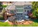Brick home's backyard features a deck, stone patio, manicured lawn, and mature trees at 2550 Bittersweet Dr, Durham, NC 27705