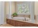 Bright bathroom featuring a soaking tub, decorative columns, and tiled floors at 2550 Bittersweet Dr, Durham, NC 27705