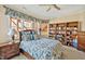 Comfortable bedroom featuring a large window, a ceiling fan, and built-in bookshelves at 2550 Bittersweet Dr, Durham, NC 27705