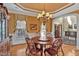 Dining room with wood table, chairs, elegant chandelier, and natural light from the windows at 2550 Bittersweet Dr, Durham, NC 27705