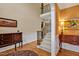 Elegant foyer with wood floors, staircase, and decorative table with artwork at 2550 Bittersweet Dr, Durham, NC 27705