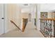 Long hallway with decorative railings leading to a bedroom featuring a stone wall at 2550 Bittersweet Dr, Durham, NC 27705