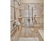 Luxurious shower with beige tiling, multiple shower heads, and accessibility bars at 2550 Bittersweet Dr, Durham, NC 27705