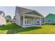 Back of house featuring covered back porch with white pillars, yard, and grass at 262 Cardovia Way, Wendell, NC 27591