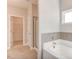 Bathroom with a tub and shower, neutral tile, and an open doorway to the walk-in closet at 262 Cardovia Way, Wendell, NC 27591