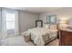 Bedroom with a bed dressed in floral linens, bedside table, and window with curtains at 262 Cardovia Way, Wendell, NC 27591