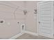 Utility or Laundry room with white walls and tile flooring with a utility sink and access to a door at 262 Cardovia Way, Wendell, NC 27591