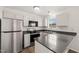 Updated kitchen with stainless appliances, dark countertops and white cabinets at 2621 Wellington Ridge Loop, Cary, NC 27518