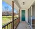Inviting porch with wooden railing, green door and sliding glass door leading into home at 2621 Wellington Ridge Loop, Cary, NC 27518