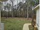 Backyard with lush lawn, surrounded by mature trees with a walkway leading to the house at 2820 Mattlyn Ct, Raleigh, NC 27613