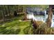 View of a lush backyard, a wooden deck and solar panels on the roof of a house in a wooded setting at 2820 Mattlyn Ct, Raleigh, NC 27613
