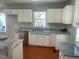 Well-lit kitchen showcasing white cabinets, granite countertops, stainless steel appliances, and hardwood floors at 2820 Mattlyn Ct, Raleigh, NC 27613